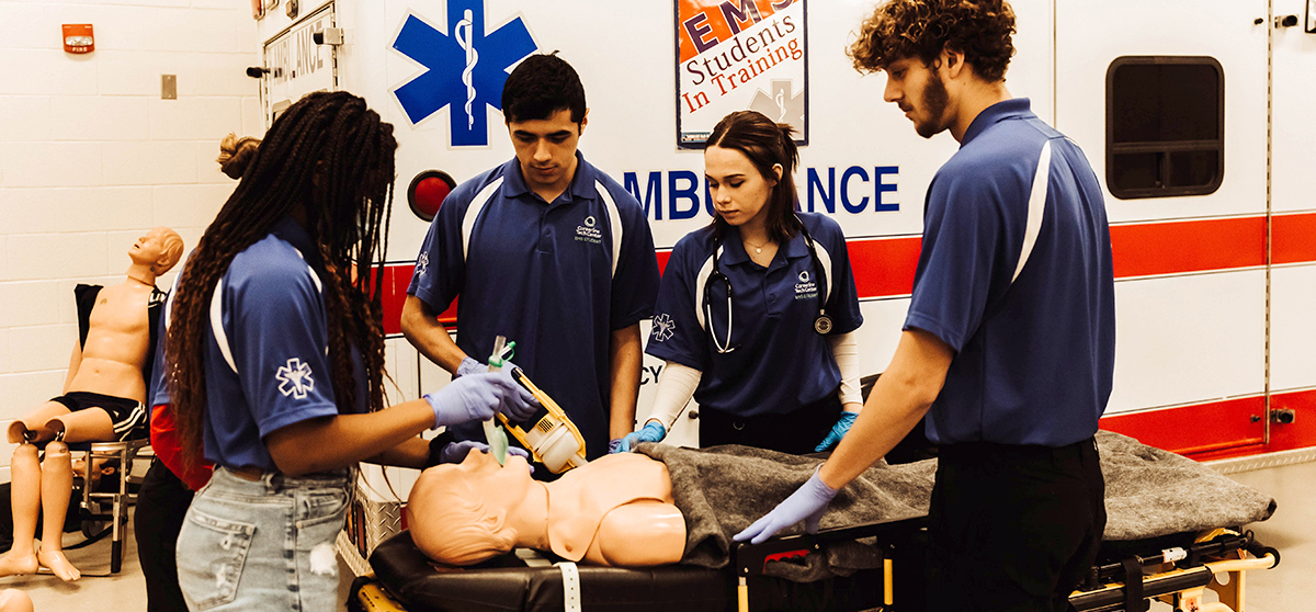 Four EMS students working on resuscitating a mannequin