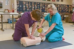 Male and Female student learning CPR